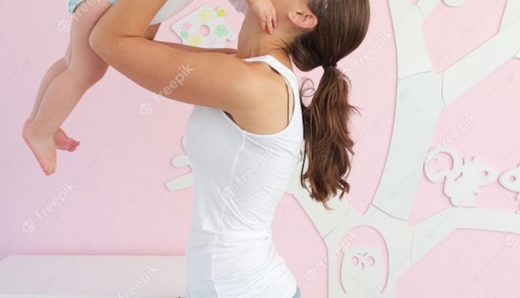 Feliz jovem mãe levantamento cute bebê saída de berço