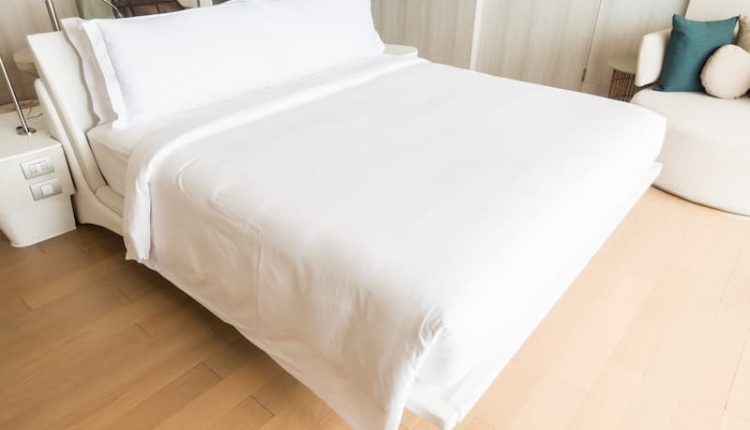 Cama de casal com almofadas brancas