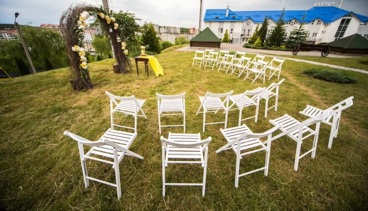 Olhe de cima em cadeiras brancas em pé ao redor altar casamento