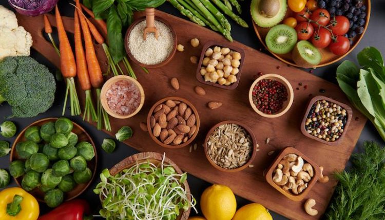 Diferentes vegetais sementes e frutas na mesa dieta saudável vista de cima plana